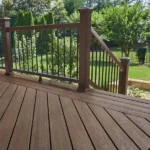 a trex enhance naturals deck with a railing and trees in the background