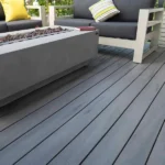 a fire pit on a TruNorth Amazon Grey composite decking in medium cool grey with subtle grain detail.