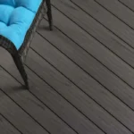 a blue cushion on a chair and a TruNorth Enviroboard Ash Grey composite decking board with soft neutral tone and realistic woodgrain finish.