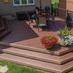 a TruNorth Enviroboard Bordeaux composite deck with rich auburn color and refined woodgrain detailing with a table and chairs and a table set on it