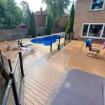 a TruNorth Enviroboard Brulee composite deck in warm golden-beige with subtle woodgrain texture with a pool and a chair
